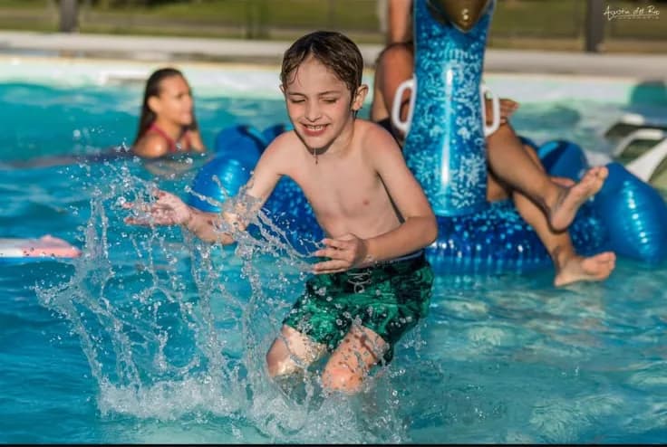 Un chico jugando en la pileta con inflables